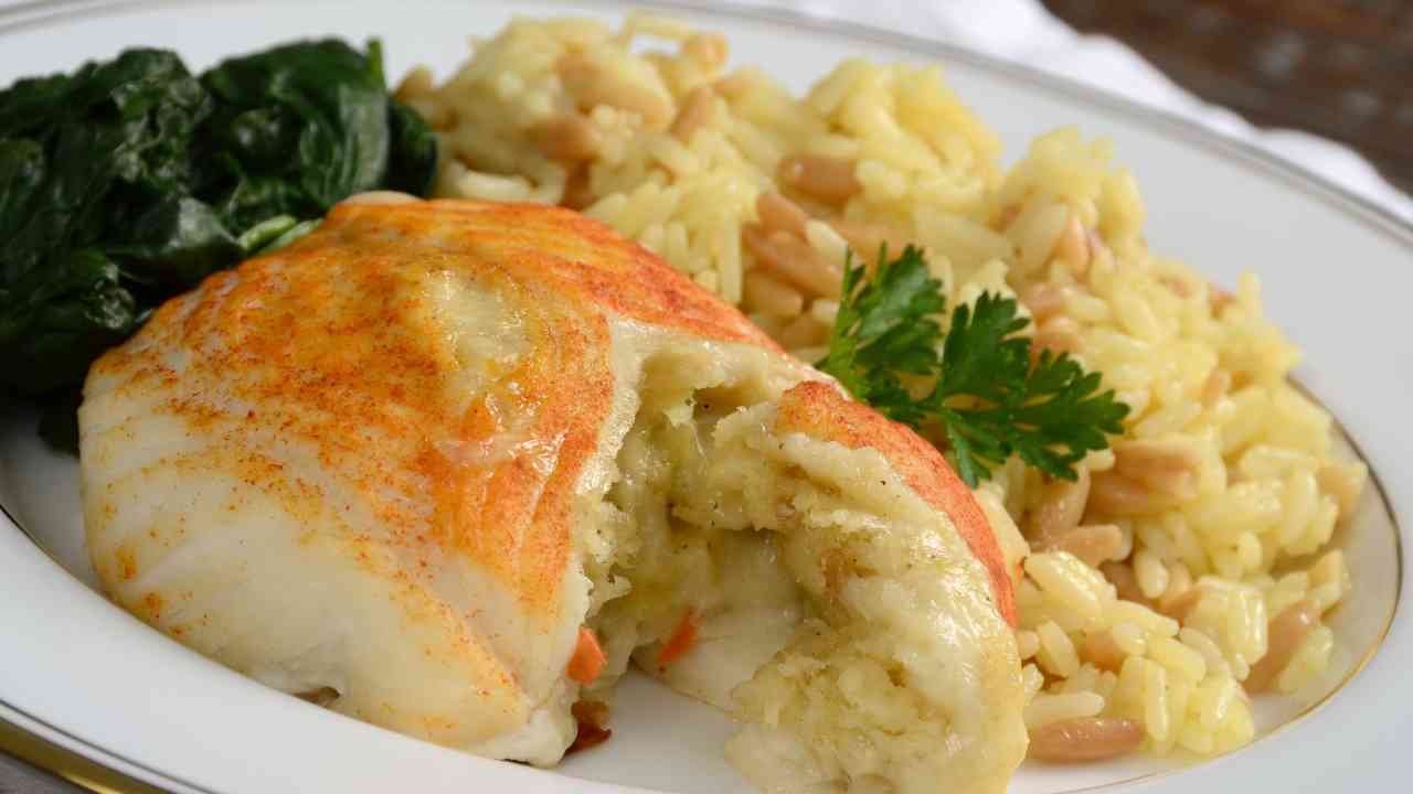 Crab stuffed sole cut open to show creamy crab filling, served with rice and greens
